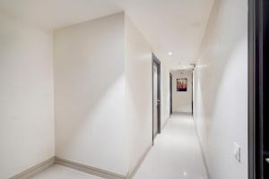 an empty hallway with white walls and a white floor at Hotel O Vatva Railway Station Formerly Anmol Palace in Ahmedabad