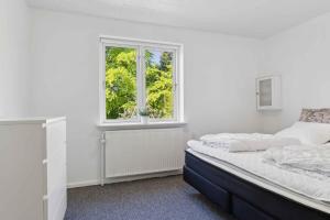 ein weißes Schlafzimmer mit einem Bett und einem Fenster in der Unterkunft Holiday Home With Hot Tub Incl Final Ing in Fur