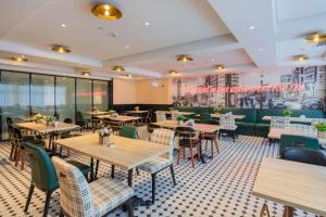 ein Restaurant mit Tischen und Stühlen in einem Raum in der Unterkunft City Comfort Premier Hotel Nanning Guangxi University Zoo Metro Station in Nanning
