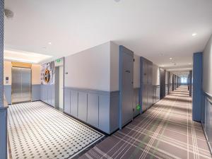 ein Flur mit blauen Türen und gefliestem Boden in der Unterkunft City Comfort Premier Hotel Nanning Guangxi University Zoo Metro Station in Nanning