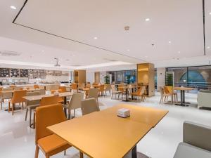 ein Restaurant mit Tischen und Stühlen und eine Cafeteria in der Unterkunft City Comfort Inn Dongguan Wangniudun in Zhongtang
