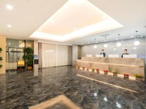 eine Lobby mit Rezeption und zwei Männern im Hintergrund in der Unterkunft GreenTree Eastern Hotel Tianjin Dongli Development Zone Xinli Metro Station in Tianjin