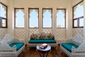 a waiting room with couches and a table and windows at The Classic Crown Udaipur - A Luxury Hotel by Lake Pichola in Jāmb
