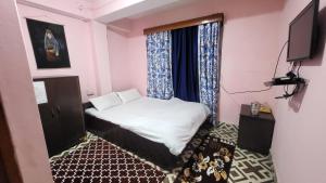 Postel nebo postele na pokoji v ubytování SAI Guest House at Gangtok Taxi Stand