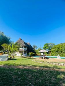 una persona seduta su una panchina di fronte a una casa di 3 bedroom own compound house a Malindi