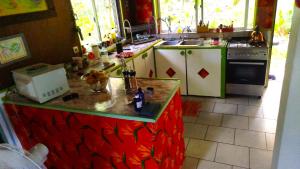 a kitchen with a red counter top and a stove at Haut de Baie de Cook Moorea 6 nuits minimum in Paopao