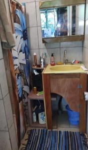 a small bathroom with a sink and a mirror at Haut de Baie de Cook Moorea 6 nuits minimum in Paopao