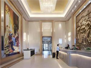 a woman standing in a lobby of a building at Vienna Hotel Shandong Jinan High-Tech Wanda Exhibition Center in Jinan