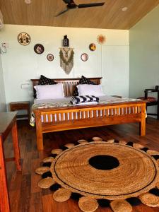 a room with a bed and a large rug at Namaste Beach Huts in Patnem