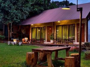 ein Haus mit einem Picknicktisch davor in der Unterkunft Phakphing Erawan Homestay - พักพิง เอราวัณ โฮมสเตย์ in Tha Kradan