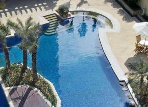 eine Draufsicht auf einen Swimmingpool mit Palmen in der Unterkunft Golden Diamond Hotel Zhongshan in Zhongshan