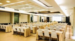 Zimmer mit Tischen, weißen Stühlen und einem Bildschirm in der Unterkunft River Kwai Village Hotel in Ban Kaeng Raboet + 219 Fotos