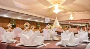 a banquet hall with white chairs and a wedding cake at K.P. Grand Hotel Chanthaburi in Chanthaburi +111 photos