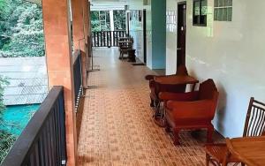 - un couloir avec des chaises et un fauteuil roulant sur une terrasse couverte dans l'établissement Saikaew Villa, à Ko Samet