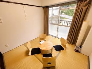 Una habitación con una mesa y sillas y una ventana grande. en Base203, en Kurume