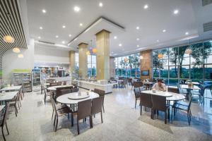 ein Esszimmer mit Tischen und Stühlen und Fenstern in der Unterkunft Kaew Samui Resort in Ban Tha Phet Noi