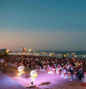 eine große Menschenmenge, die auf Stühlen am Strand sitzt in der Unterkunft Supar Royal Beach Hotel in Ban Plau + 193 Fotos