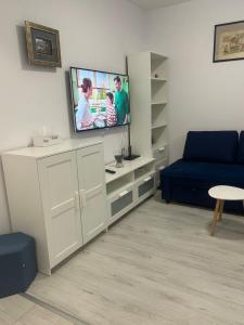 ein Wohnzimmer mit Fernseher und blauem Sofa in der Unterkunft Kamu Military Residence Studio in Chiajna