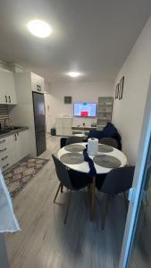 eine Küche und ein Wohnzimmer mit Tisch und Stühlen in der Unterkunft Kamu Military Residence Studio in Chiajna