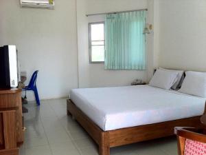 ein Schlafzimmer mit einem Bett und einem Fernseher darin in der Unterkunft Chumphon Park Resort in Chumphon