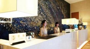 zwei Frauen stehen an einer Theke in einem Raum in der Unterkunft Bestay Hotel Express Nanjing Xinjiekou in Nanjing