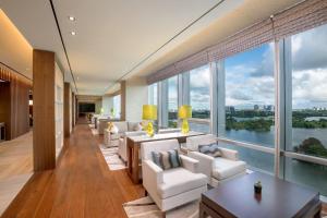 仰光LOTTE Hotel Yangon的客厅配有白色椅子和大窗户