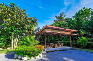 a pavilion with a picnic table in a garden at Panita Resort in Ban Phang Phrao