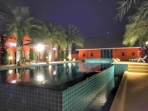 ein Swimmingpool vor einem Haus bei Nacht in der Unterkunft Thada Chateau Hotel in Ban Bu Lamduan