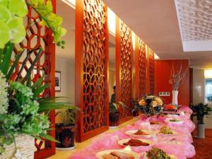 a long table with plates of food on it at Xian Qujiang Yinzuo Hotel in Xi'an