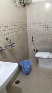 a bathroom with a toilet and a sink and a bucket at Hotel akty Jaisalmer in Jaisalmer