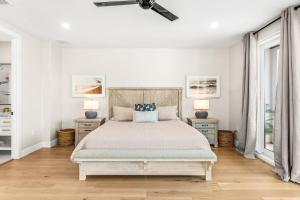 a bedroom with a bed with two night stands and two windows at 40 8th Avenue in Indialantic
