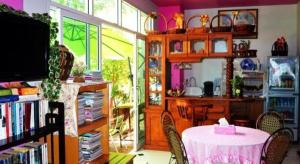 ein Zimmer mit einem Tisch, Stühlen und einem Bücherregal in der Unterkunft Sairougn Seaview Hotel in Ban Ko Kwang