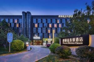 ein Gebäude mit einem Schild vor einer Straße in der Unterkunft Palace Hotels Beijing Yongfeng Nan(S) Subway Station in Peking