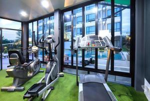 einen Fitnessraum mit einem Fitnessraum mit einem Laufband und einem Fahrrad in der Unterkunft UDTel Boutique Hotel Udonthani in Ban Dong Kheng