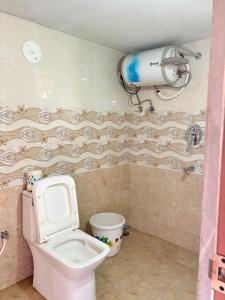 a bathroom with a toilet and a blow dryer on the wall at 11 Haven Street Kodaikanal in Kodaikānāl