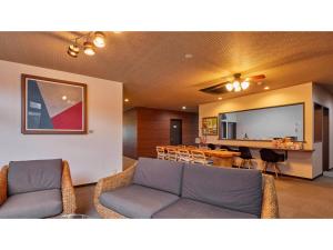 uma sala de estar com um sofá e uma sala de jantar em AMA TERRACE - Vacation STAY 31145v em Amami