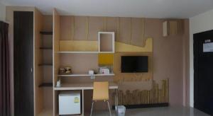 ein Zimmer mit einem Schreibtisch und einem Fernseher an der Wand in der Unterkunft The Rice Hotel in Roi Et + 199 Fotos