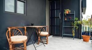 Zimmer mit einem Tisch, 2 Stühlen und einem Tisch in der Unterkunft Journey Hostel Surat in Ban Tha Kup