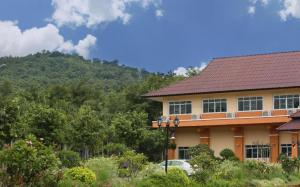 une maison avec une montagne en arrière-plan dans l'établissement Rajapruek Place, à Chiang Mai