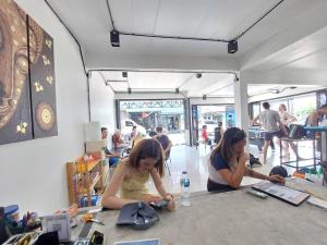 zwei Frauen, die an einem Tisch sitzen und ihre Handys ansehen in der Unterkunft Czone Hostel in Ko Tao