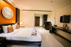 ein Hotelzimmer mit einem Bett, auf dem ein Stofftier liegt in der Unterkunft Wiangkaew Hotel in Ban Fai Kaeo