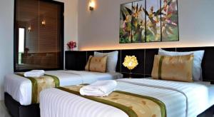 1 Schlafzimmer mit 3 Betten und weißer Bettwäsche in der Unterkunft The Convenience Hotel in Ban Si Than + 194 Fotos