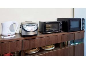 um balcão de cozinha com um micro-ondas e uma torradeira em AMA TERRACE - Vacation STAY 31138v em Amami
