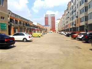 a parking lot with parked cars in a city at Jinjiang Inn Ulanqab Jining 1st Middle School in Jining