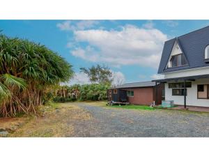 uma casa com uma entrada de cascalho ao lado de uma casa em AMA TERRACE - Vacation STAY 31138v em Amami