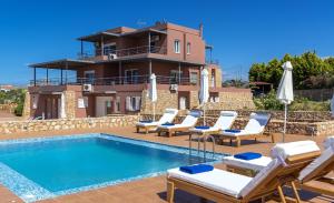 a villa with a swimming pool in front of a house at Horizon Villa Kampani in Kambánion