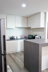 Una cocina con gabinetes blancos y encimera. en Vivacity Jazz Suite 3 by De Kumang Homestay, en Kuching
