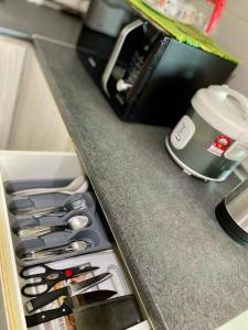 Una encimera de cocina con un cajón con muchos cuchillos. en Vivacity Jazz Suite 3 by De Kumang Homestay, en Kuching 22 fotos más