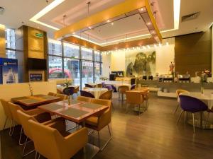 a restaurant with tables and chairs and a cafeteria at Jinjiang Metropolo Hotel - Ningde Wanda Plaza in Ningde