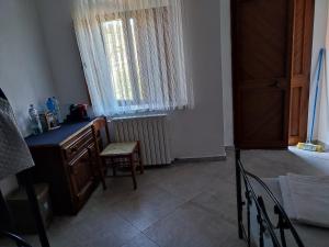 ein Zimmer mit einem Schreibtisch und einem Stuhl und einem Fenster in der Unterkunft B&B Da GIOVANNI in Masseria di Rusciano + 10 Fotos